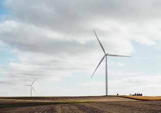 two white windmills on brown field during daytime