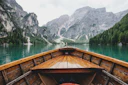 The bow of a wooden rowboat pointed across green water toward grey cliffs