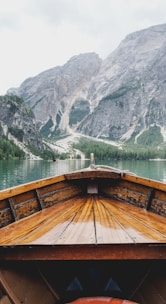 brown wooden boat moving towards the mountain