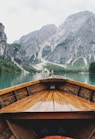 brown wooden boat moving towards the mountain