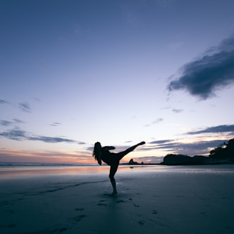 silhouette of person kicking on mid air