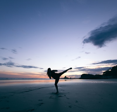 silhouette of person kicking on mid air