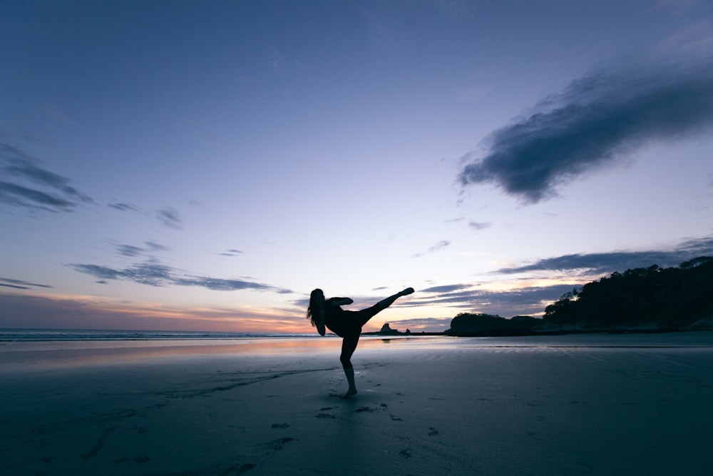 silhouette of person kicking on mid air