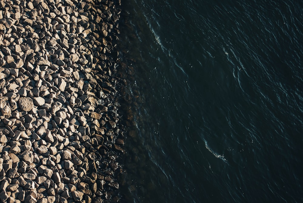 black and brown stones on body of water