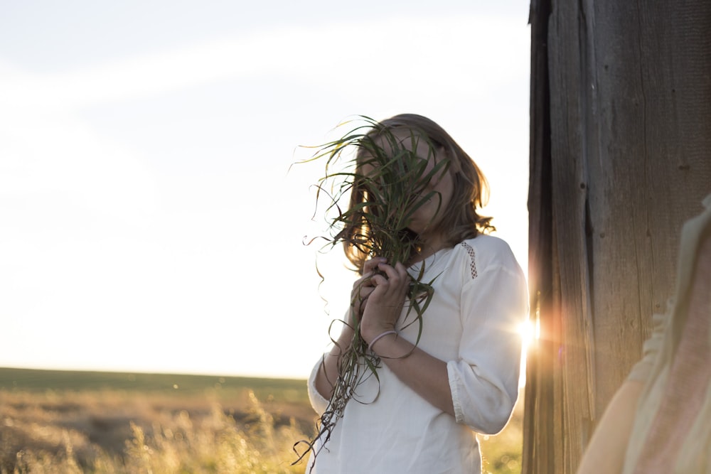 femme tenant des plantes vertes