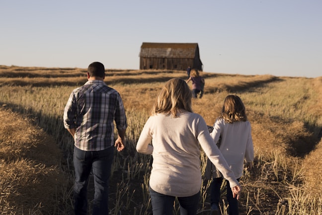 man and women walks on grasses during daytime