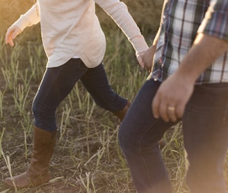 two person wearing denim pants on grass field