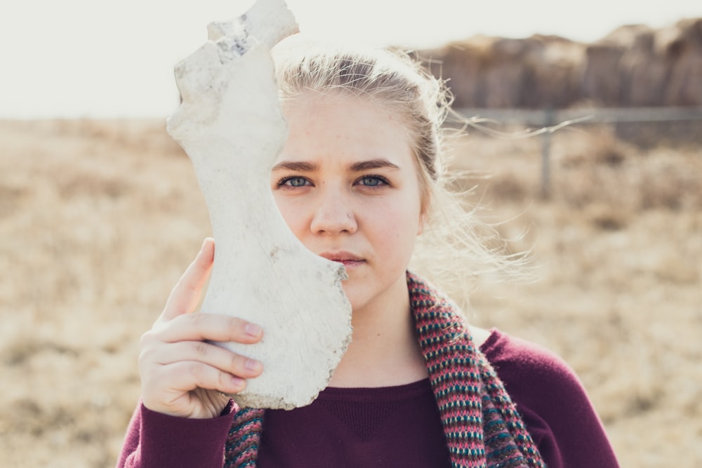 woman holding white animal bone