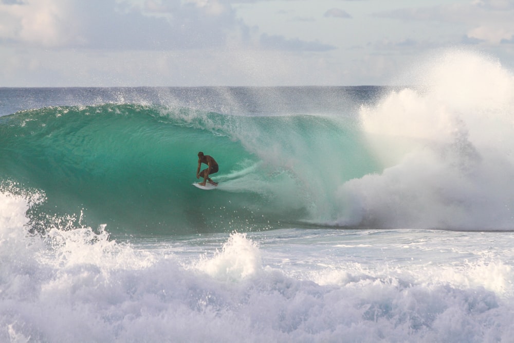 homme équitation planche de surf sous la vague de la mer pendant la journée