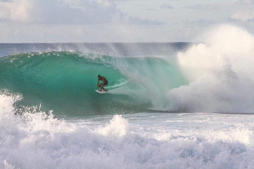 un ragazzo surfa nell'Oceano alle Hawaii