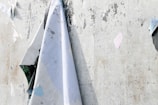 Close-up of a textured wall with layered posters and peeling paint, evoking urban memory.