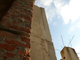 Wide shot of a partially built masonry wall under a clear sky.