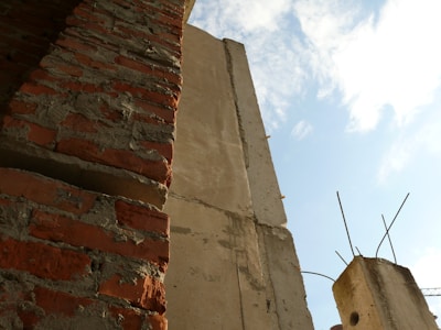 Wide shot of a partially built masonry wall under a clear sky.