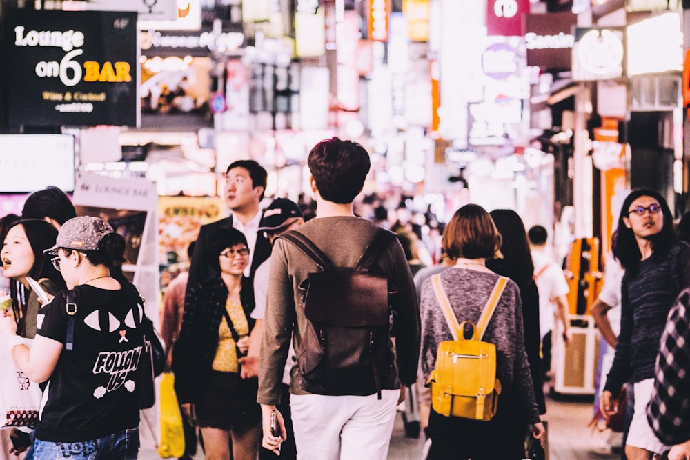 photography of man wearing brown backpack near lounge on 6 bar