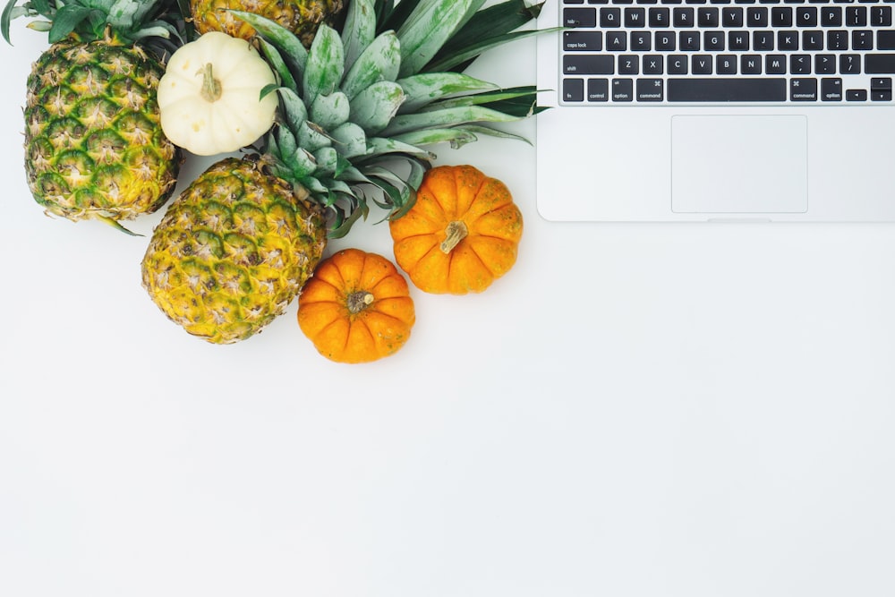 frutta dell'ananas verde vicino al MacBook