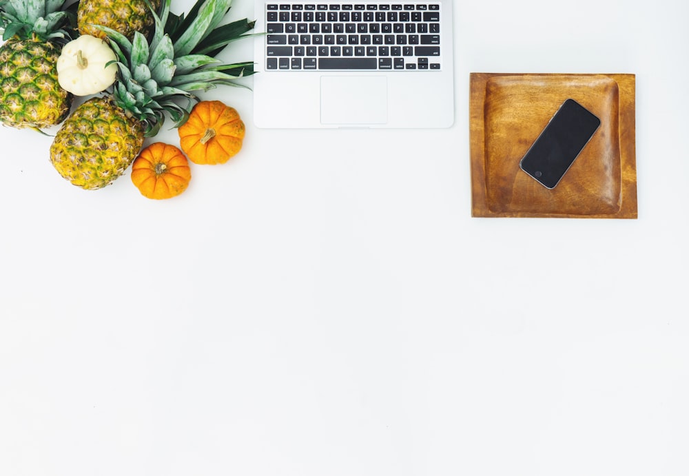 fruits near laptop on white surface