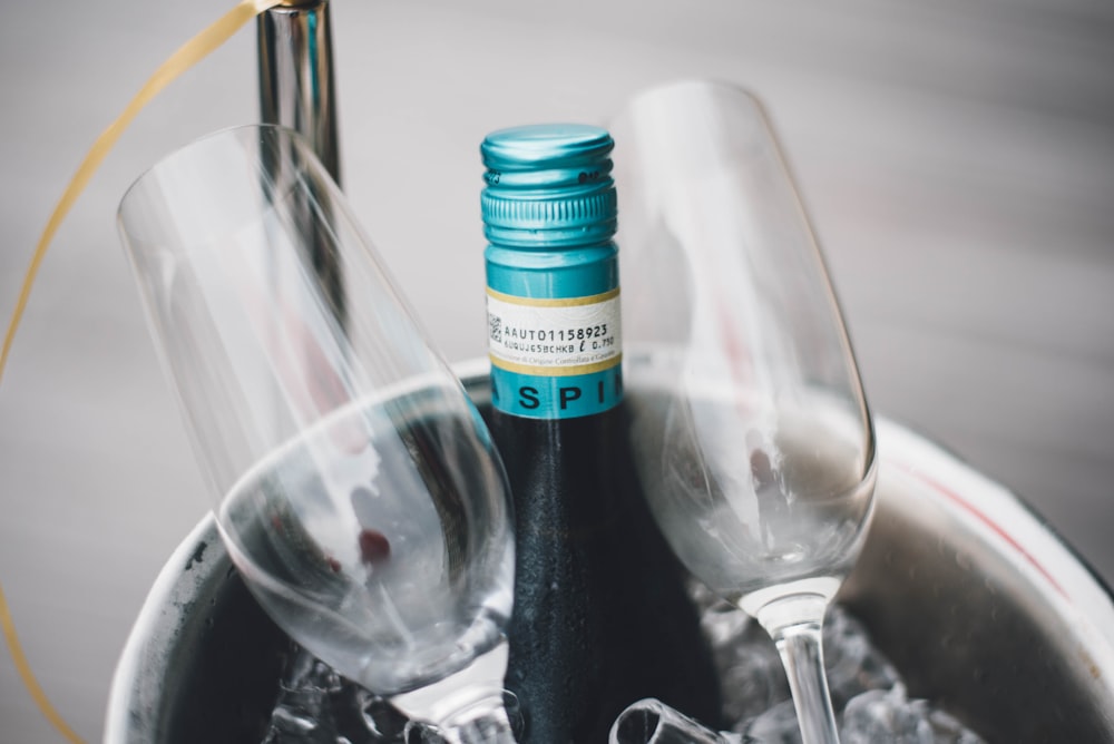 bouteille de vin à côté de deux verres à flûte en macrophotographie