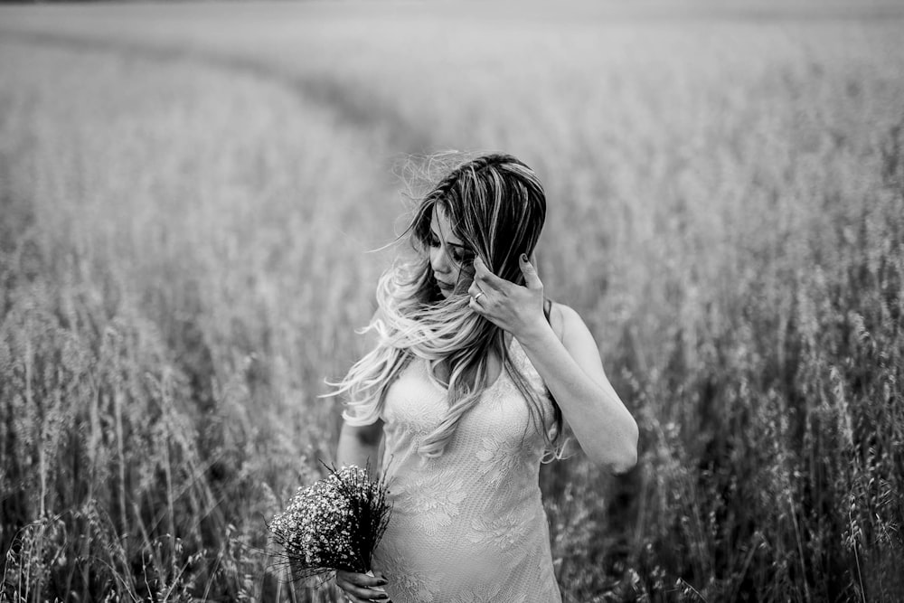 grayscale photo of woman surrounded by grass