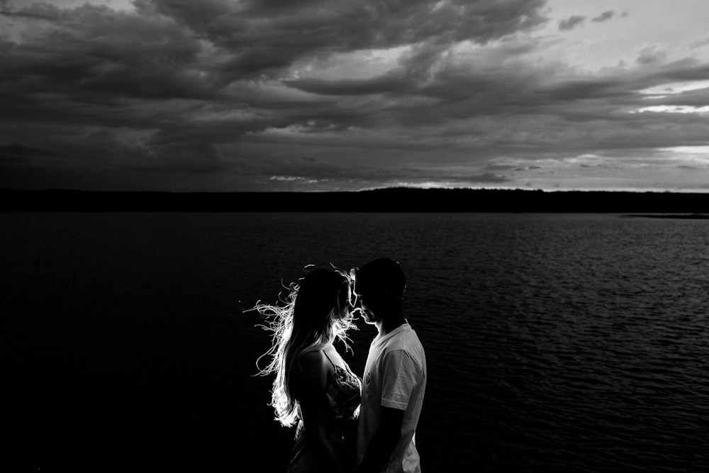 grayscale photo of couples near body of water