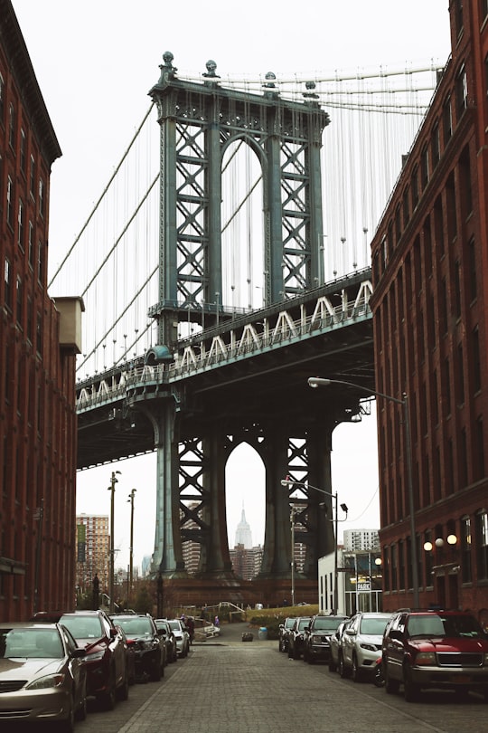 vehicles parked along the road near metal bridge in Brooklyn Bridge Park United States