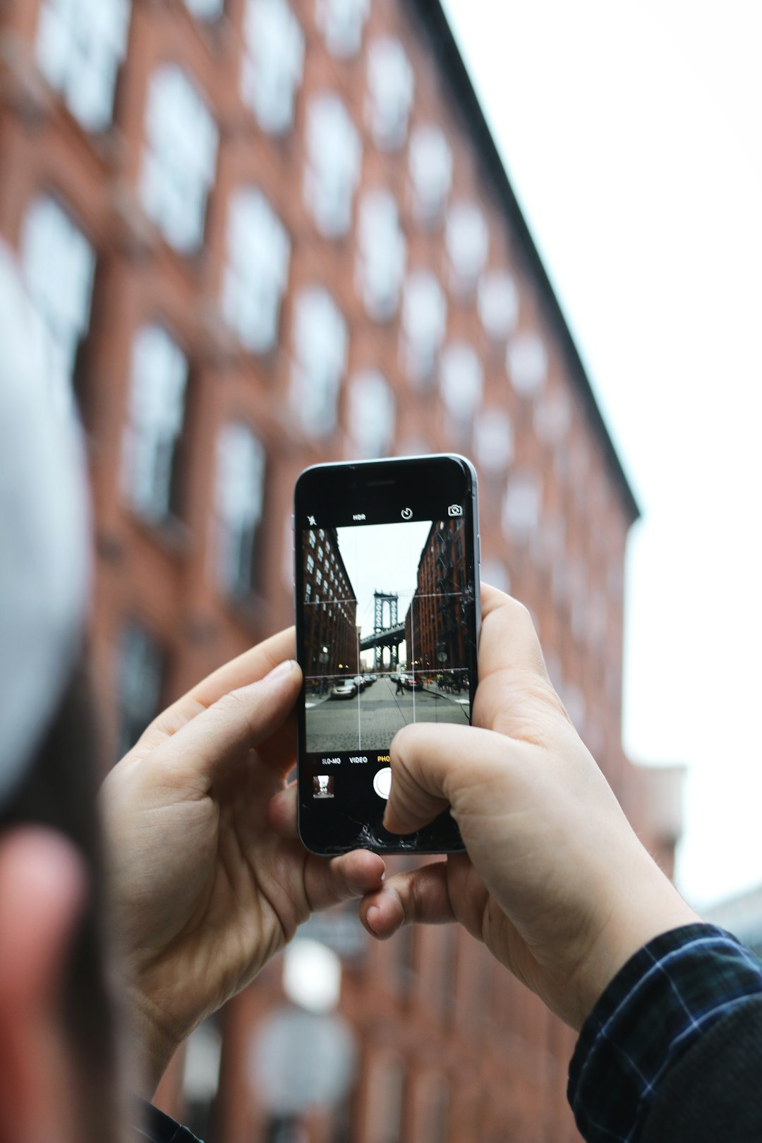 A person taking a picture of urban buildings with their phone.