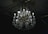 A luxurious crystal chandelier with multiple glowing bulbs hanging from an ornate ceiling. The chandelier features intricate designs with gleaming crystals and golden decorations, casting a soft light in a dimly lit room.