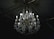 A luxurious crystal chandelier with multiple glowing bulbs hanging from an ornate ceiling. The chandelier features intricate designs with gleaming crystals and golden decorations, casting a soft light in a dimly lit room.