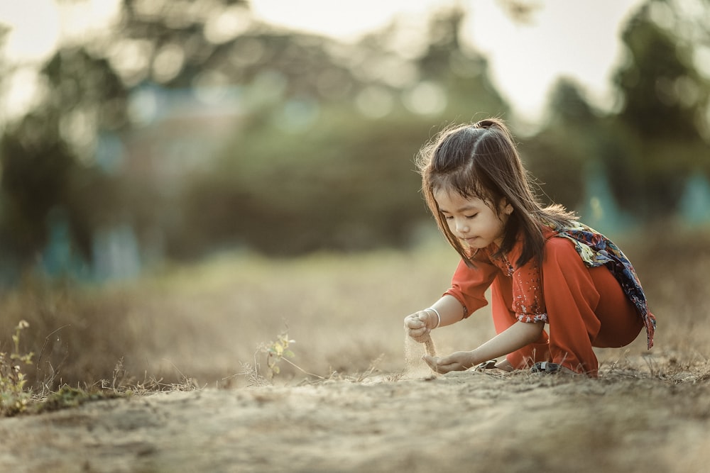 girl playing sand during daytime