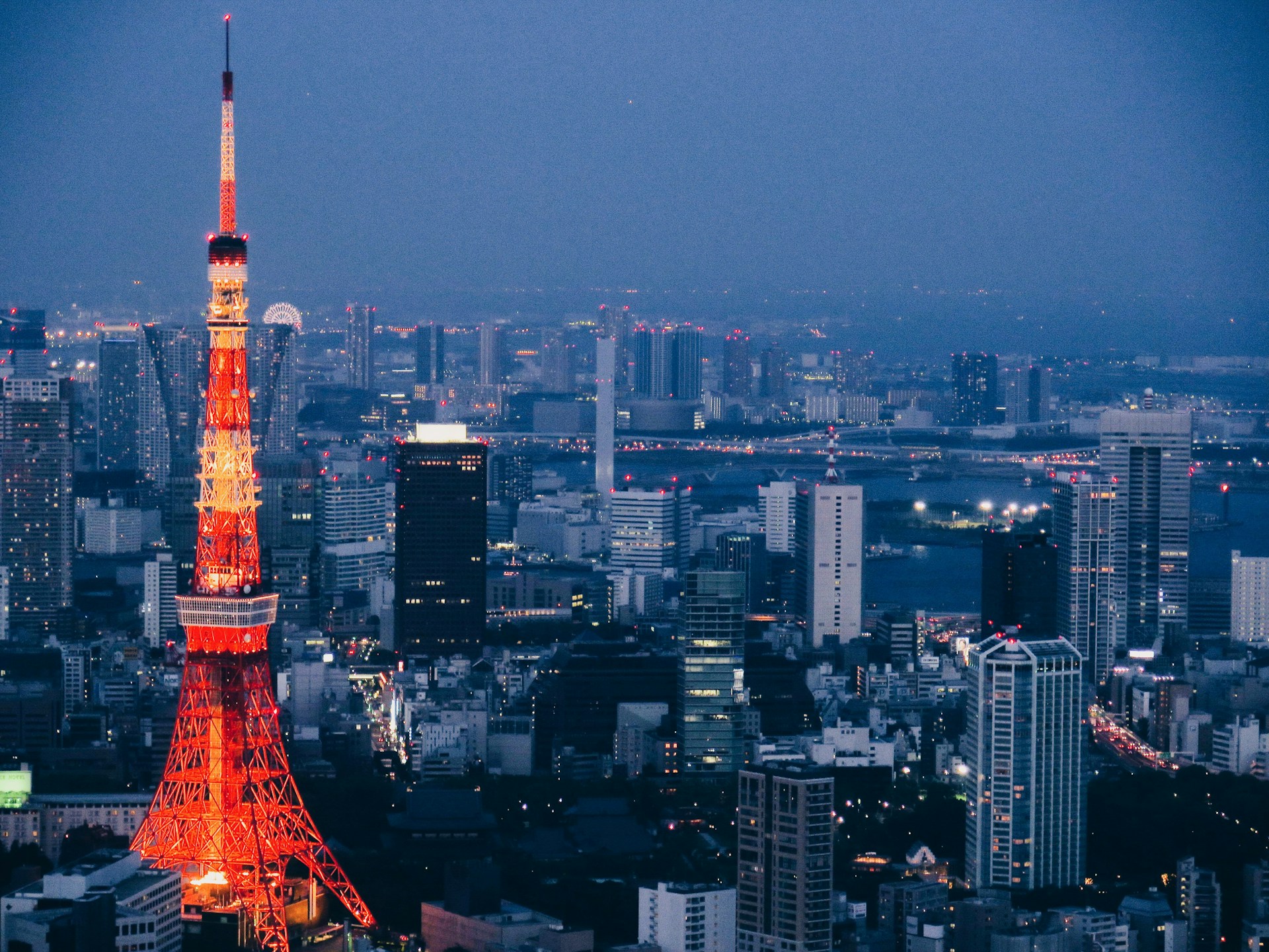 A vibrant cityscape at dawn with red hues highlighting the national news column.