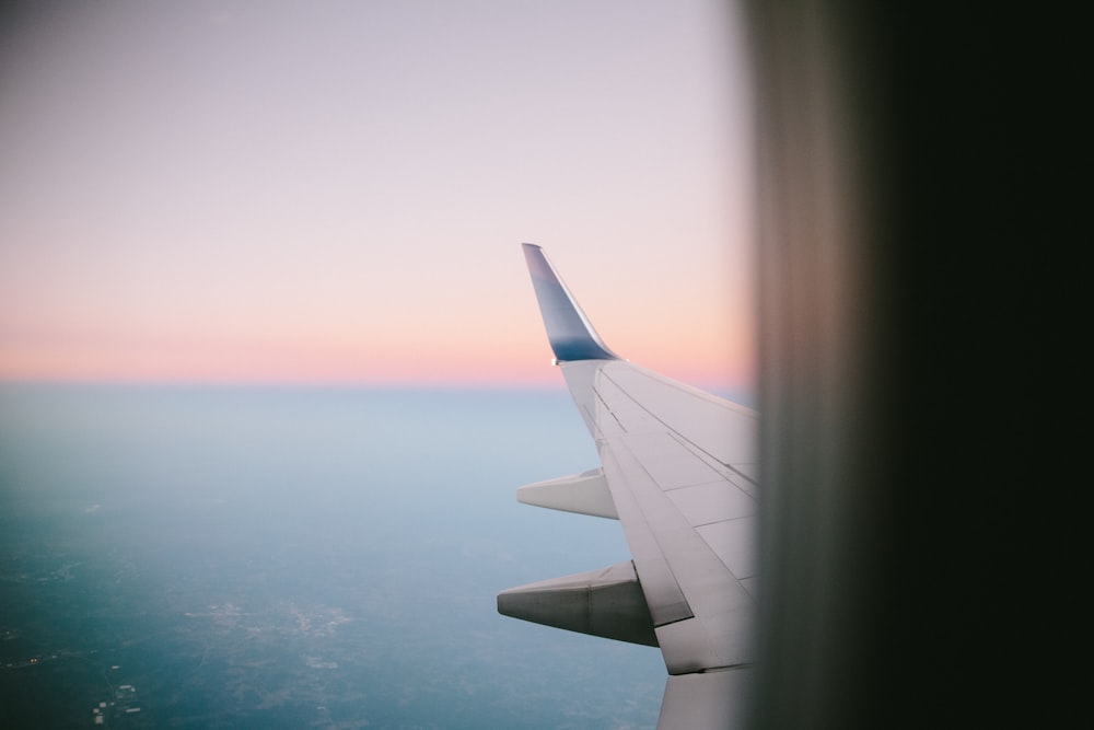 Foto des Himmels und des Flugzeugflügels, aufgenommen aus dem Inneren des Flugzeugs