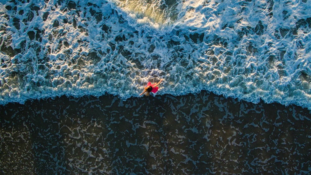 해안에 서 있는 여성의 항공 사진