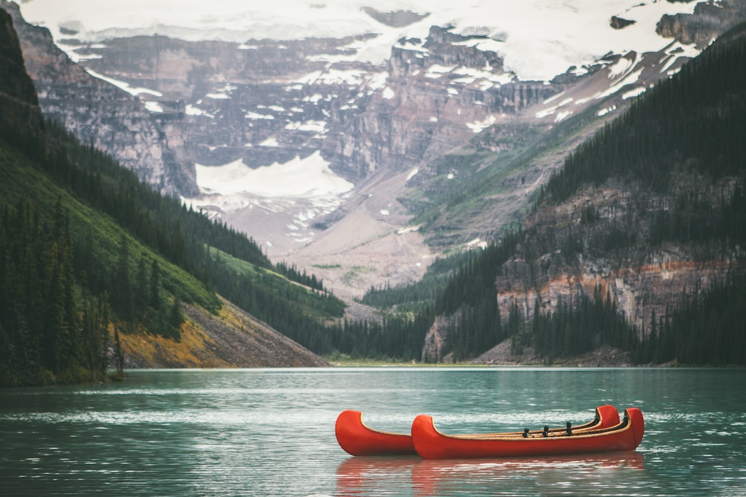 Red canoes on a lake with mountains - Photo by Andrew Ly Lei | best digital marketing - London, Bristol and Bath marketing agency