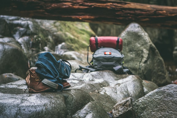 two gray and orange backpacks on gray rocks at daytime