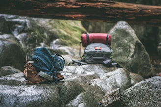 two gray and orange backpacks on gray rocks at daytime