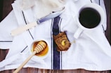 A rustic wooden table set with homemade bread and a jar of honey catching morning light.