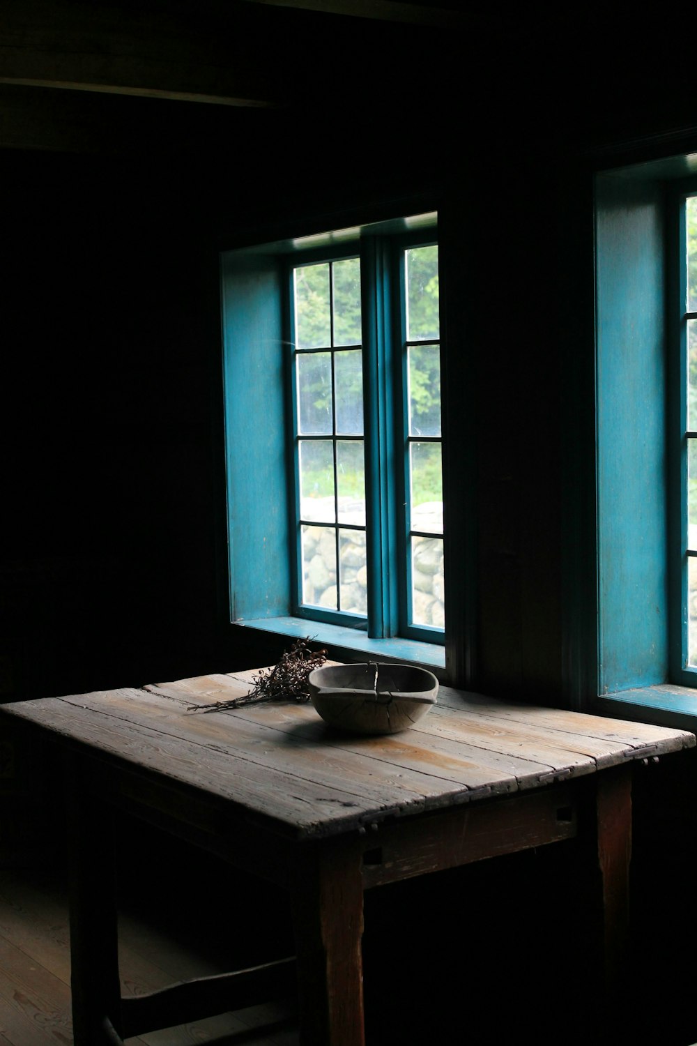 square brown wooden dining table near blue windowpane