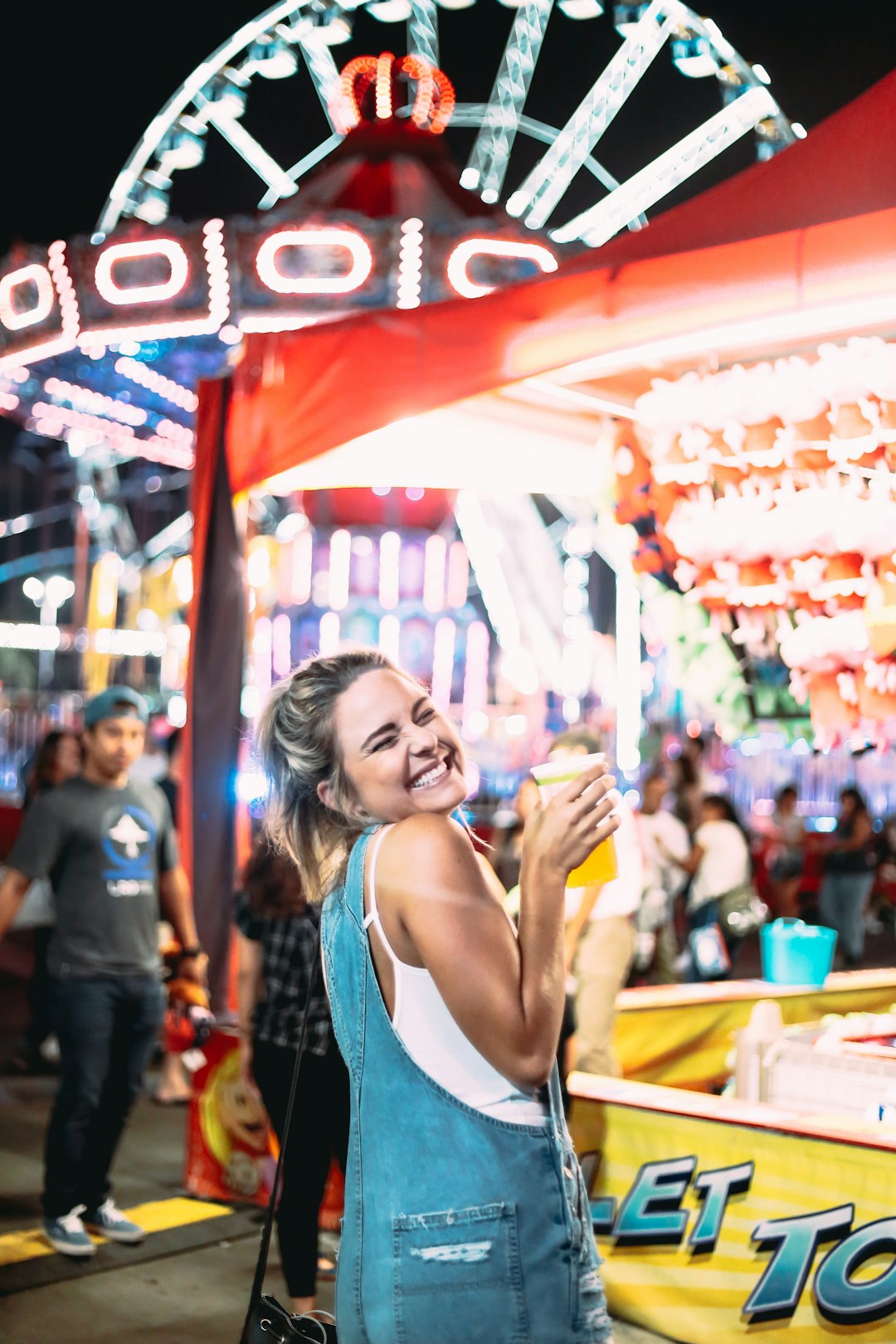 a woman standing in front of a carnival ride