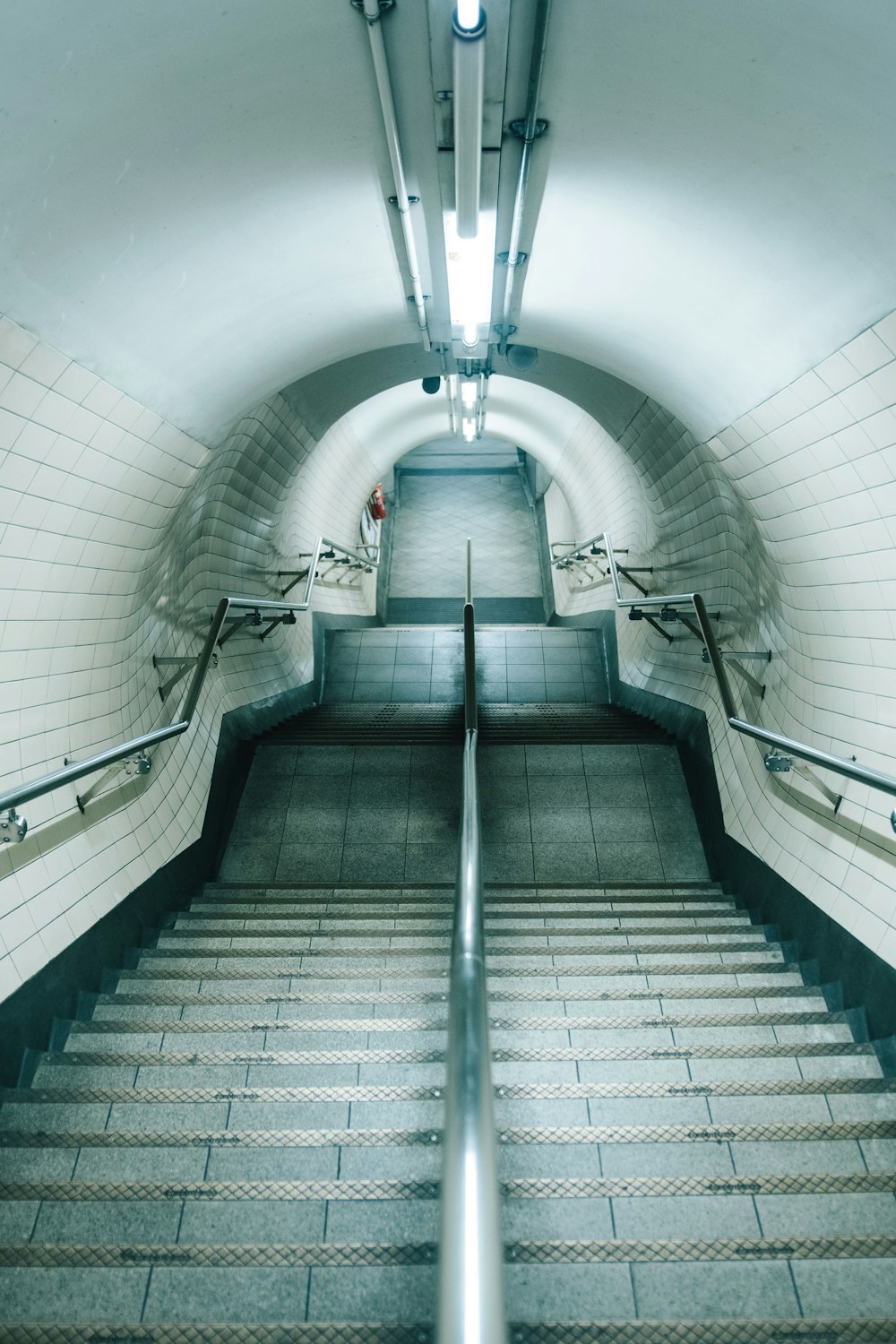 photography of stairs with silver hand rail