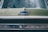 The front grill of a classic Chevrolet vehicle with a vintage emblem. The car is green, and the chrome details are prominent, giving a nostalgic feel.