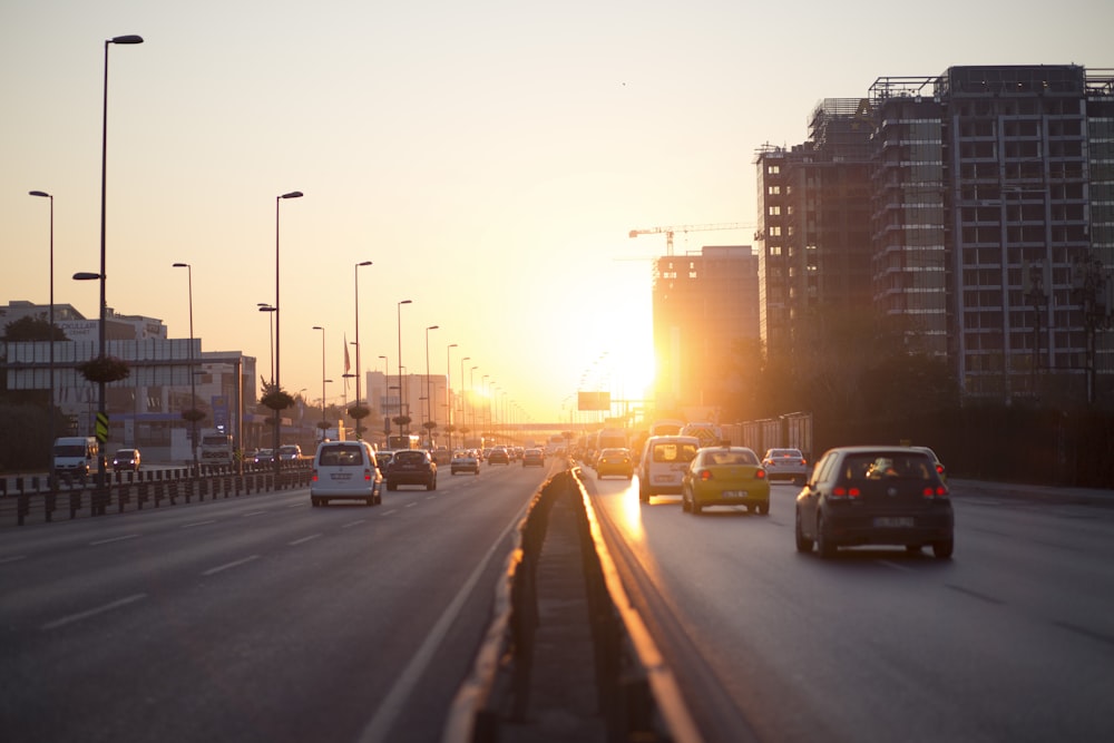 Fahrzeuge auf der Autobahn in der Nähe von Gebäuden während der goldenen Stunde