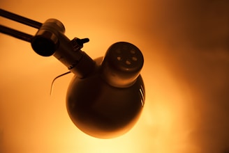 Detailed shot of a metal lamp base with visible hand-forged marks and a matte dark bronze color.