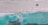 Aerial view of a large turquoise body of water adjacent to a sandy, barren landscape with visible tire tracks, and a construction vehicle near the edge. The scene embodies a contrast between the serene water and the structured, industrialized land.