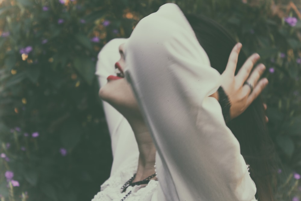 femme tenant ses cheveux près des arbres