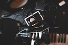 flat-lay photo of headphones, MIDI keyboard, and speaker on black surface
