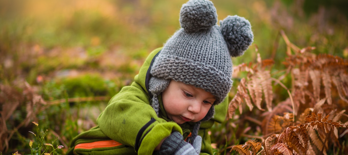 selective focus photo of baby on green grass field