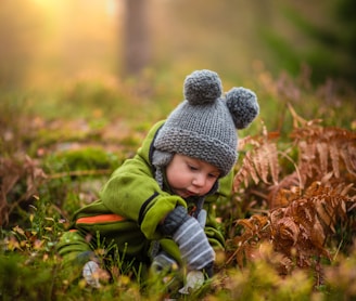selective focus photo of baby on green grass field