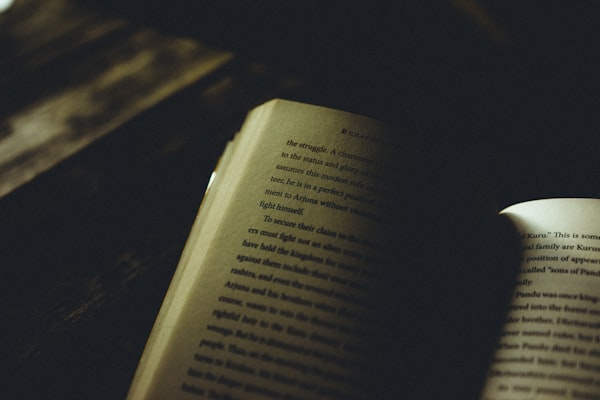 Aufgeschlagenes Buch auf dunklem Holztisch