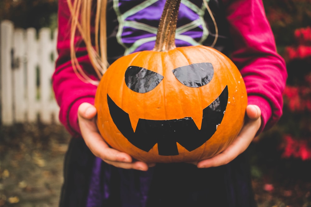 Fotografia di messa a fuoco selettiva della persona che tiene la zucca