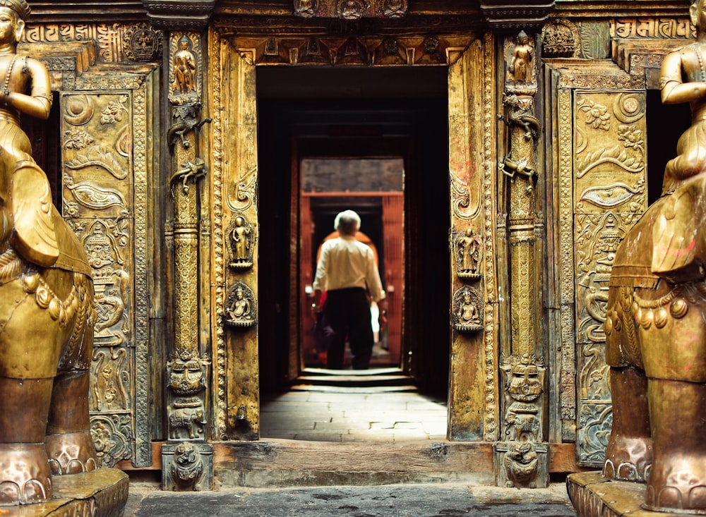 man standing in front of brown doorway during daytime