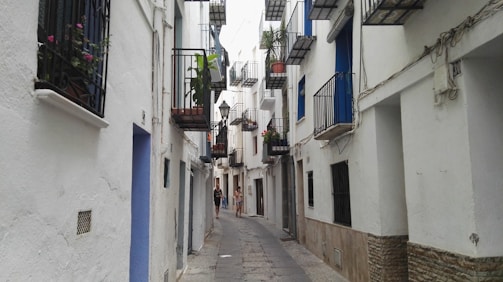 A solo traveler exploring narrow streets filled with white buildings.